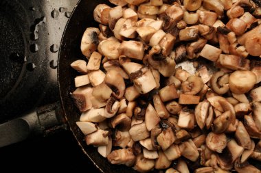 Bir tavada mantar parçaları. Tavada çiğ mantar parçaları. çiğ mantar pişirmek