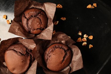 Çikolatalı kek, cevizli çikolatalı kek, kuru üzüm ve rendelenmiş çikolata ve koyu siyah arka planda koyu çikolatalı çikolata. Yemek tarifi kitabı yapmak için mükemmel..