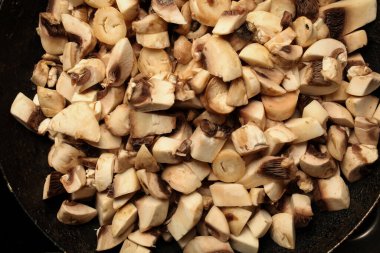 Bir tavada mantar parçaları. Tavada çiğ mantar parçaları. çiğ mantar pişirmek