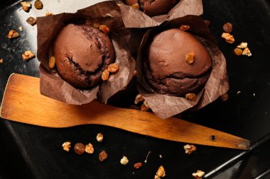 Çikolatalı kek, cevizli çikolatalı kek, kuru üzüm ve rendelenmiş çikolata ve koyu siyah arka planda koyu çikolatalı çikolata. Yemek tarifi kitabı yapmak için mükemmel..