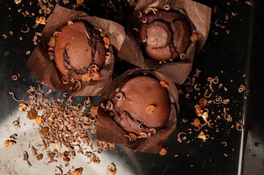 Çikolatalı kek, cevizli çikolatalı kek, kuru üzüm ve rendelenmiş çikolata ve koyu siyah arka planda koyu çikolatalı çikolata. Yemek tarifi kitabı yapmak için mükemmel..