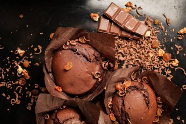 Çikolatalı kek, cevizli çikolatalı kek, kuru üzüm ve rendelenmiş çikolata ve koyu siyah arka planda koyu çikolatalı çikolata. Yemek tarifi kitabı yapmak için mükemmel..