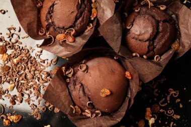 Çikolatalı kek, cevizli çikolatalı kek, kuru üzüm ve rendelenmiş çikolata ve koyu siyah arka planda koyu çikolatalı çikolata. Yemek tarifi kitabı yapmak için mükemmel..