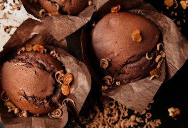 Çikolatalı kek, cevizli çikolatalı kek, kuru üzüm ve rendelenmiş çikolata ve koyu siyah arka planda koyu çikolatalı çikolata. Yemek tarifi kitabı yapmak için mükemmel..