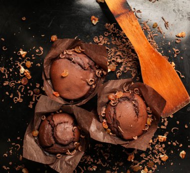 Çikolatalı kek, cevizli çikolatalı kek, kuru üzüm ve rendelenmiş çikolata ve koyu siyah arka planda koyu çikolatalı çikolata. Yemek tarifi kitabı yapmak için mükemmel..