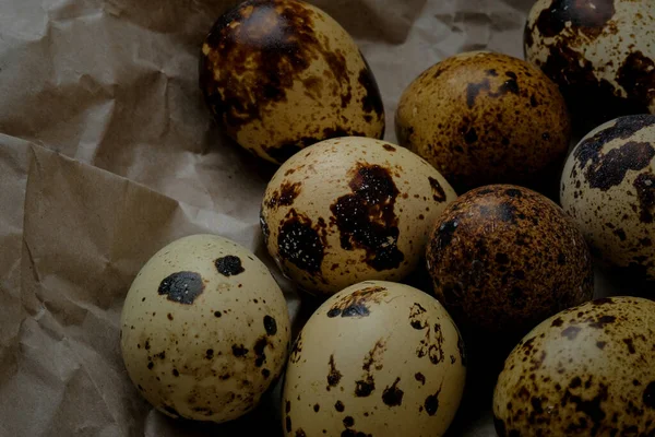 Easter quail eggs on craft paper and rustic burlap background.