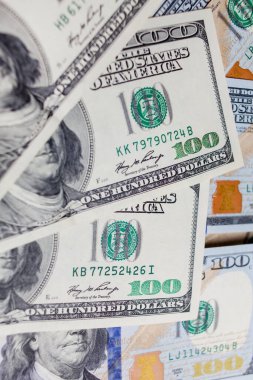 Önünde ve arkasında 100 dolarlık banknotlar var. Gelir, yatırım, başarılı iş. Amerikan dolarlarının yakın plan çekimleri, Amerikan dolarlarının arka plan dokusu