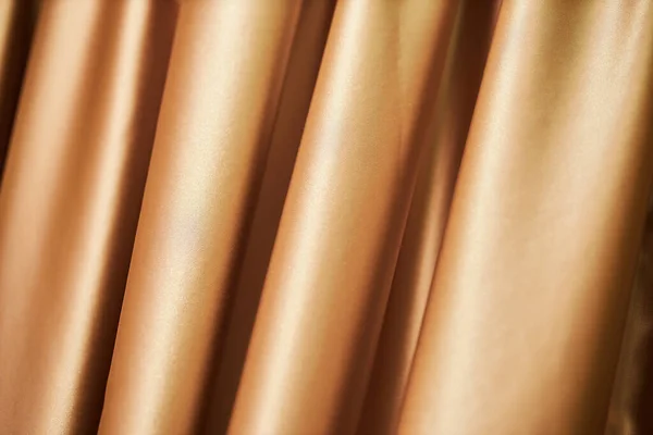 theatrical golden curtain. close-up of golden curtain - photographed, not illustrated. Golden curtain background.