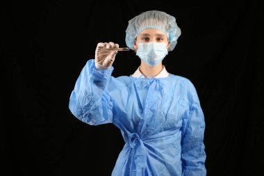 Bir hemşire, maskeli bir virüs uzmanı termometre tutuyor. 2021 salgını. Coronavirüs 'ü durdurun. COVID-19. Viral, koronavirüs aşısı. Karantinaya alın. Avrupa 'da koronavirüs, dünya. sıcaklık taraması