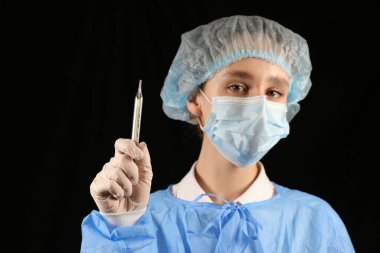 Bir hemşire, maskeli bir virüs uzmanı termometre tutuyor. 2021 salgını. Coronavirüs 'ü durdurun. COVID-19. Viral, koronavirüs aşısı. Karantinaya alın. Avrupa 'da koronavirüs, dünya. sıcaklık taraması