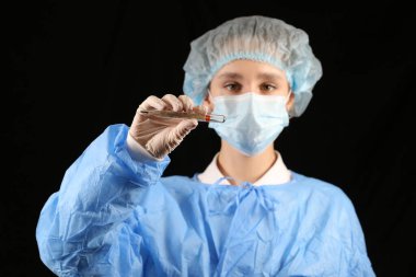 Bir hemşire, maskeli bir virüs uzmanı termometre tutuyor. 2021 salgını. Coronavirüs 'ü durdurun. COVID-19. Viral, koronavirüs aşısı. Karantinaya alın. Avrupa 'da koronavirüs, dünya. sıcaklık taraması