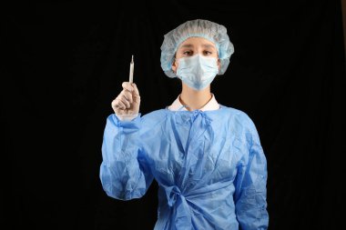 Bir hemşire, maskeli bir virüs uzmanı termometre tutuyor. 2021 salgını. Coronavirüs 'ü durdurun. COVID-19. Viral, koronavirüs aşısı. Karantinaya alın. Avrupa 'da koronavirüs, dünya. sıcaklık taraması