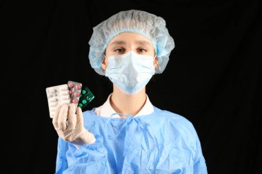 Bir hemşire, maskeli bir virüs uzmanı elinde haplar tutuyor. 2021 salgını. Coronavirüs 'ü durdurun. COVID-19. Virüs, koronavirüs aşısı. Karantinaya alın. Avrupa 'da koronavirüs, dünya. Coronavirus aşısı