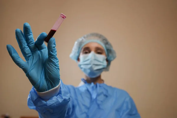 Bir hemşire, Çin, Wuhan 'dan alınmış koronavirüs pozitif kan örneği içeren bir test tüpü tutuyor. 2019 nCoV salgını. Coronavirüs 'ü durdurun. MERS. Bir virüs uzmanı koronavirüs aşısı düşünüyor. Grip, kuş gribi.