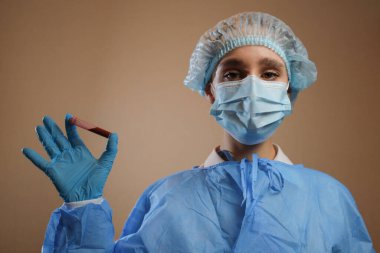 Bir hemşire, Çin, Wuhan 'dan alınmış koronavirüs pozitif kan örneği içeren bir test tüpü tutuyor. 2019 nCoV salgını. Coronavirüs 'ü durdurun. MERS. Bir virüs uzmanı koronavirüs aşısı düşünüyor. Grip, kuş gribi.