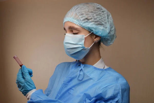 Bir hemşire, Çin, Wuhan 'dan alınmış koronavirüs pozitif kan örneği içeren bir test tüpü tutuyor. 2019 nCoV salgını. Coronavirüs 'ü durdurun. MERS. Bir virüs uzmanı koronavirüs aşısı düşünüyor. Grip, kuş gribi.