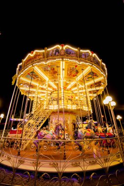 Akşamları ve akşamları lunaparktaki çocuk atlıkarıncasında. Geceleyin eğlence parkı. Lunapark, arka plan için resim.