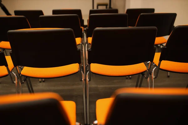 Black and orange plastic conference chairs. black and orange chairs in the conference room. background of black and orange chairs.