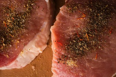 Kesme tahtasındaki dana biftek. Plastik kesim tahtasında baharatlı dana biftek. Baharatlı çiğ biftek. Yakın plan fotoğraf. Kesme tahtasındaki çiğ biftek..