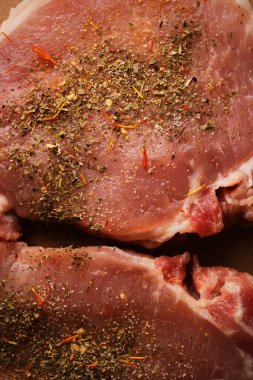 Kesme tahtasındaki dana biftek. Plastik kesim tahtasında baharatlı dana biftek. Baharatlı çiğ biftek. Yakın plan fotoğraf. Kesme tahtasındaki çiğ biftek..