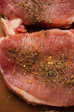 Kesme tahtasındaki dana biftek. Plastik kesim tahtasında baharatlı dana biftek. Baharatlı çiğ biftek. Yakın plan fotoğraf. Kesme tahtasındaki çiğ biftek..