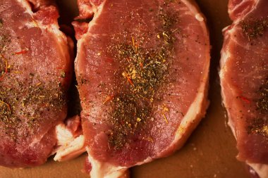Kesme tahtasındaki dana biftek. Plastik kesim tahtasında baharatlı dana biftek. Baharatlı çiğ biftek. Yakın plan fotoğraf. Kesme tahtasındaki çiğ biftek..