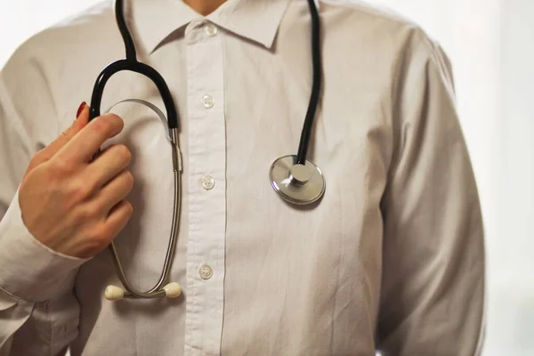 Steteskop kullanan bir doktor. Steteskoplu beyaz önlüklü bir doktor. Koronavirüs tedavisi. Beyaz önlüklü bir doktor elinde steteskop tutuyor. Sağlık hizmetleri kavramı.