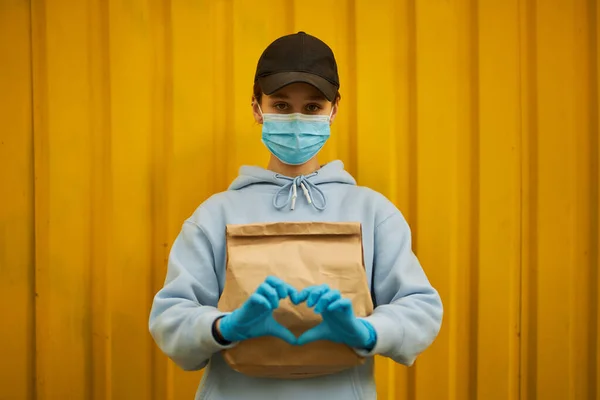 Meisjeskoerier Met Een Medisch Masker Medische Handschoenen Gele Achtergrond Bezorging Stockafbeelding