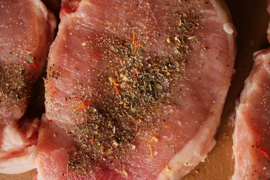 Kesme tahtasındaki dana biftek. Plastik kesim tahtasında baharatlı dana biftek. Baharatlı çiğ biftek. Yakın plan fotoğraf. Kesme tahtasındaki çiğ biftek..