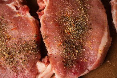 Kesme tahtasındaki dana biftek. Plastik kesim tahtasında baharatlı dana biftek. Baharatlı çiğ biftek. Yakın plan fotoğraf. Kesme tahtasındaki çiğ biftek..