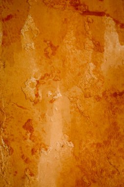 Bright grunge wall texture. Grunge vintage stone wall background texture with orange texture of husk, stain paint. Vintage orange wall wallpaper. Texture wall, orange grunge background, stain.