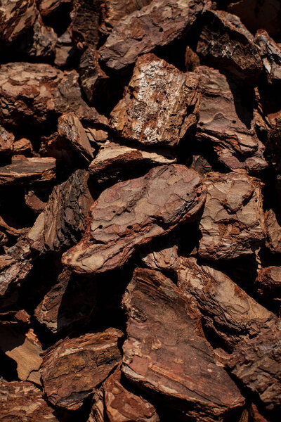 Дробленая текстура древесной коры задний план. Измельченный коричневый кора дерева для украшения и мульчирования или для детской площадки. Кусочки коры деревьев, как на заднем плане. текстура коры крупным планом.