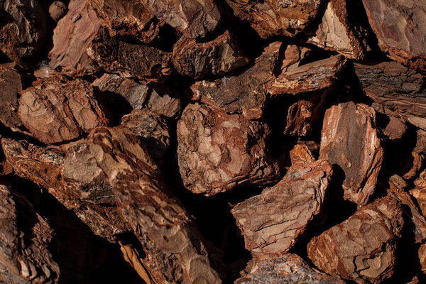 Дробленая текстура древесной коры задний план. Измельченный коричневый кора дерева для украшения и мульчирования или для детской площадки. Кусочки коры деревьев, как на заднем плане. текстура коры крупным планом.