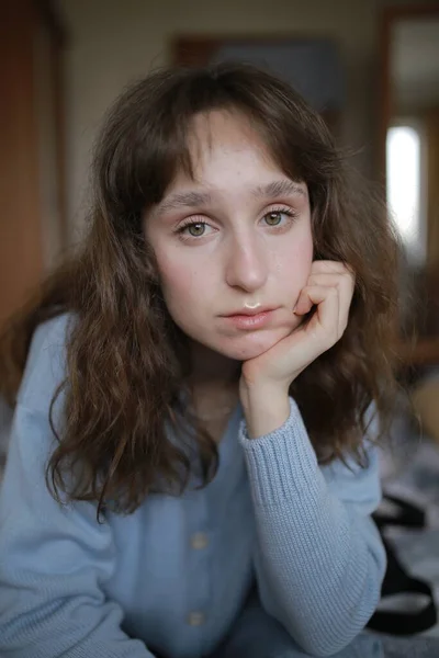 Young sad brown-haired Caucasian woman dressed in a blue blouse — Stock Photo, Image