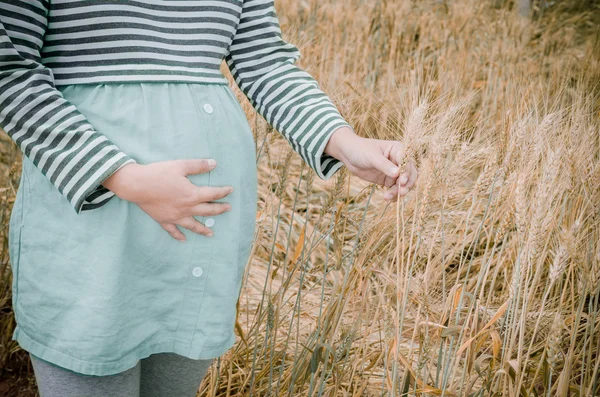 Happy family: a young beautiful pregnant woman walking in the wh — Stock Photo, Image