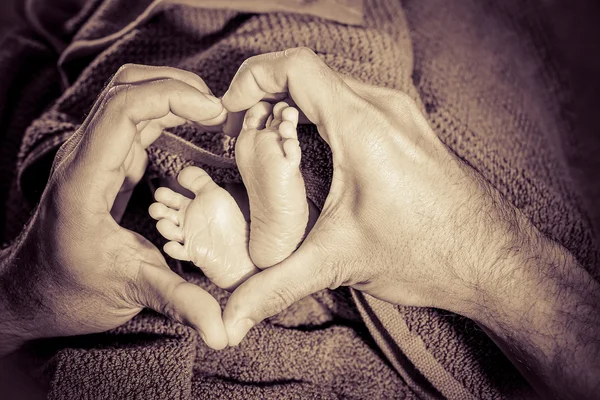 Baby feet in father hands — Stock Photo, Image