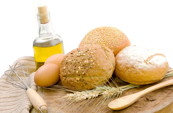 Pane fresco e grano sul legno — Foto Stock