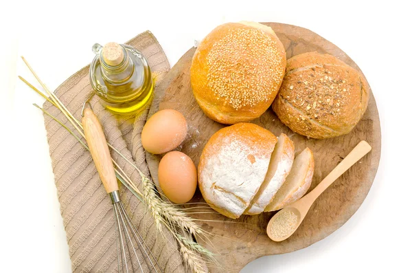 木头上的新鲜面包和小麦 — 图库照片