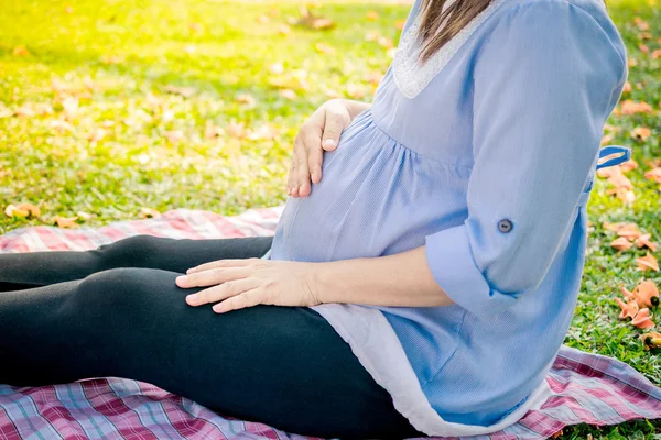 Young pregnant woman relaxing in park outdoors, — Stock Photo, Image