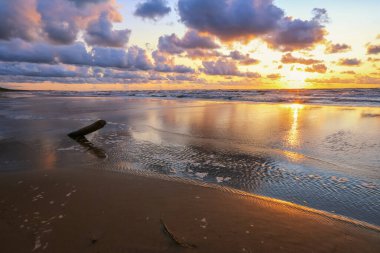 Fırtınalı yaz günbatımında küçük bir kasaba olan Saulkrasti 'de beyaz kumlu plaj. 