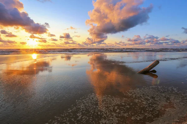 Fırtınalı yaz gününde, renkli günbatımında küçük bir kasaba olan Saulkrasti 'de beyaz kumlu sahil. 
