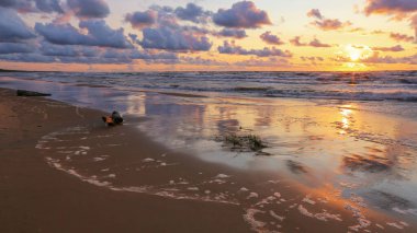 Letonya 'nın popüler turistik mekanı Beach Saulkrasti' de fırtınalı bir gün batımı. 