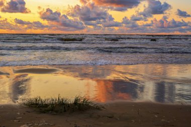 Letonya 'nın popüler turistik mekanı Beach Saulkrasti' de fırtınalı bir gün batımı. 