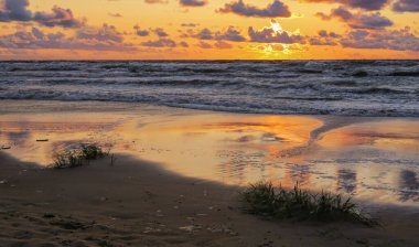 Letonya 'nın popüler turistik mekanı Beach Saulkrasti' de fırtınalı bir gün batımı. 