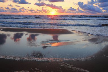 Letonya 'nın popüler turistik mekanı Beach Saulkrasti' de fırtınalı bir gün batımı. 