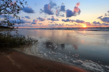 Letonya 'nın popüler turistik mekanı Beach Saulkrasti' de fırtınalı bir gün batımı. 