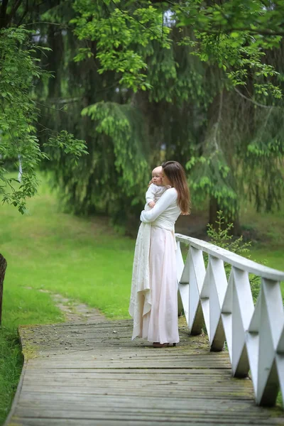 Красивая Мать Длинном Платье Обнимает Сына Деревянном Мосту Парке — стоковое фото