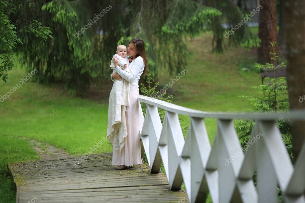 Красивая мать в длинном платье обнимает сына на мосту в парке 456890734 Ларасток