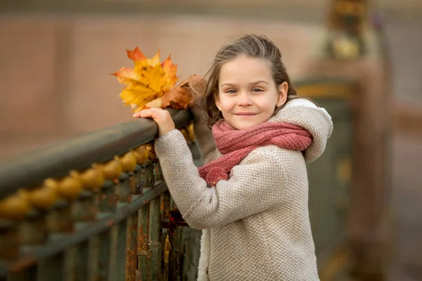 橋の上に立つ女の子サンクトペテルブルクでは 秋の花束が手に残っています 髪に風 — ストック写真