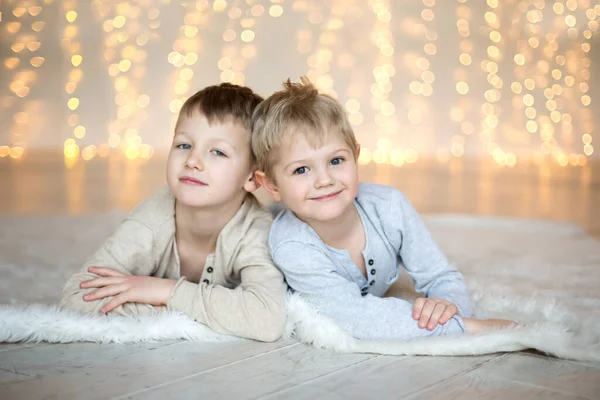 Dos Niños Pequeños Tumbados Suelo Sobre Fondo Las Luces Navidad — Foto de Stock